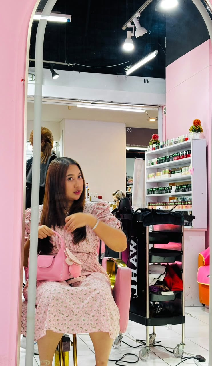 Sera in a pink floral dress inside a pink salon