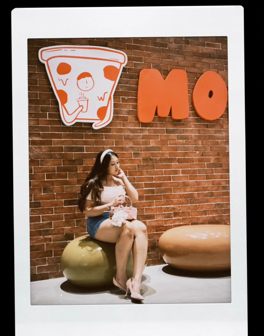 Sera posing in front of an orange wall
